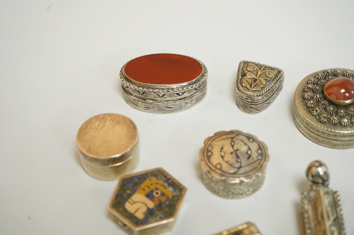 A collection of assorted pill boxes including one modern circular silver, a Mexican 925, six continental white metal, one inset with chalcedony and two with niello decoration and three other unmarked white metal pill box